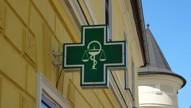 Semnul unei farmacii cu simbolul tradițional al sănătății și echității.