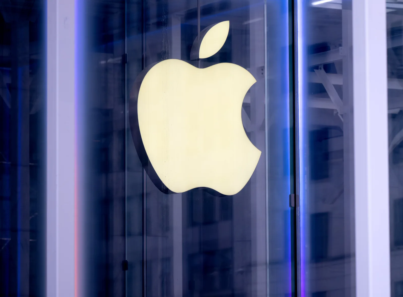 Logo-ul Apple iluminat pe un fundal modern și tehnologic.