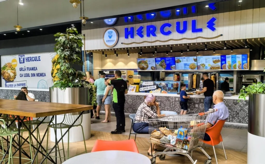 Interiorul unei taverne grecești cu clienți și decor modern.