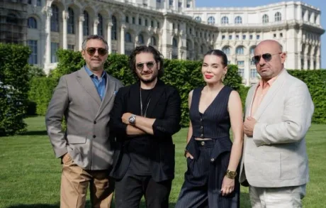 Cei patru membri ai juriului MasterChef România în fața unei clădiri impunătoare.