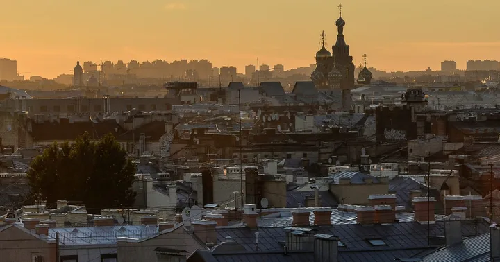 Peisaj urban din Sankt Petersburg la apus, cu clădiri istorice și biserici.