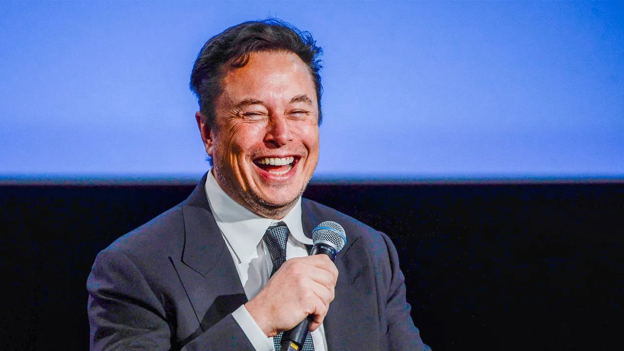 Elon Musk zâmbind în timpul unui discurs despre tehnologie și inovație.