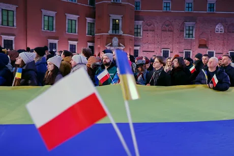Oameni cu steaguri ucrainene și poloneze la un protest în Polonia.