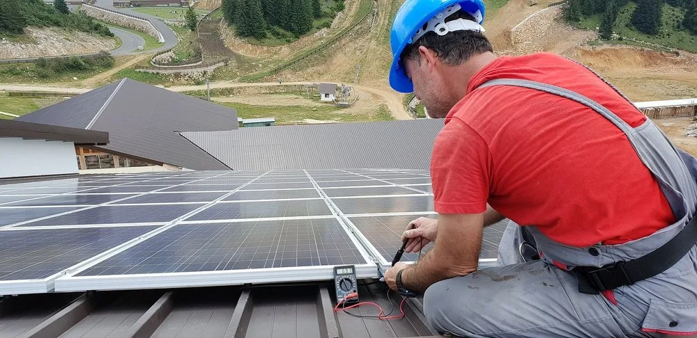 Un prosumator verifică panourile solare instalate pe acoperiș.