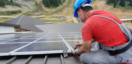 Un prosumator verifică panourile solare instalate pe acoperiș.