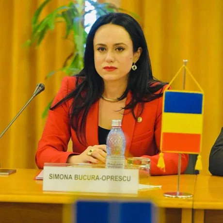 Simona Bucura-Oprescu la conferința Organizației de Femei a PSD, cu steagul României în fundal.