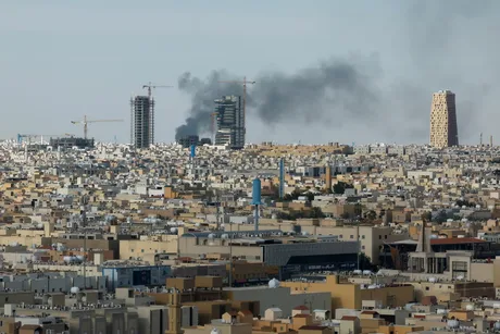 Peisaj urban din Arabia Saudită, cu fum și clădiri în construcție.
