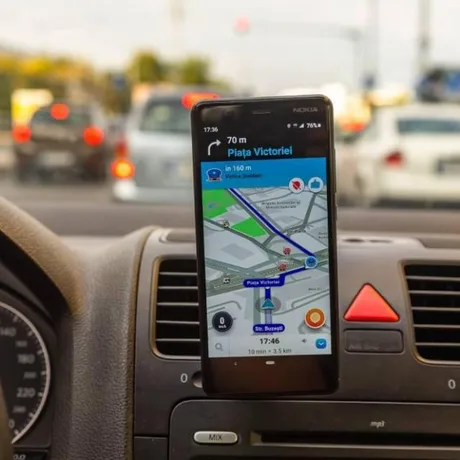 Aplicație de navigație pe un telefon mobil în trafic aglomerat.