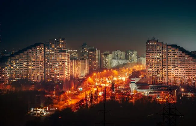 Vedere nocturnă a Chișinăului, cu clădiri iluminate și străzi aglomerate.