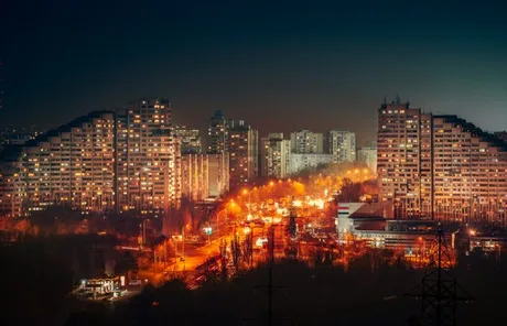 Vedere nocturnă a Chișinăului, cu clădiri iluminate și străzi aglomerate.