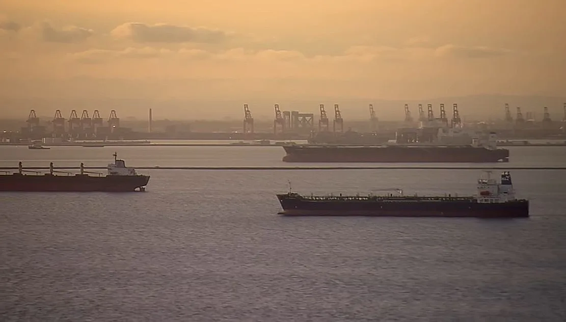 Nave de transport maritim pe fundalul unui apus de soare.