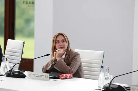 Giorgia Meloni ascultând cu atenție la o întâlnire oficială.