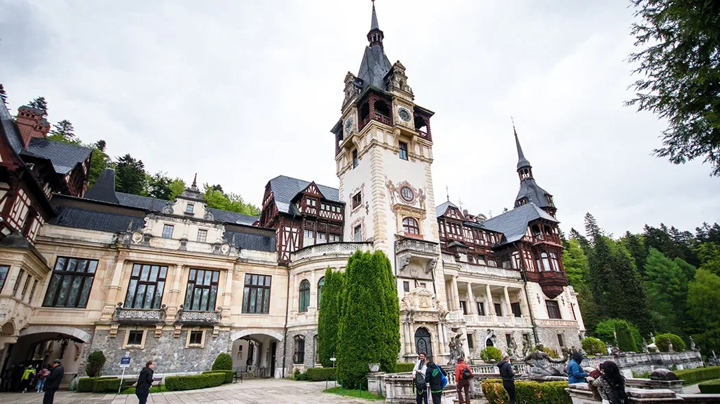 Castelul Peleș, un obiectiv turistic emblematic din România, înconjurat de natură.