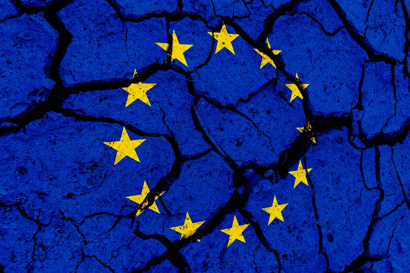 Steagul Uniunii Europene pe un fundal crăpat, simbolizând provocările actuale.