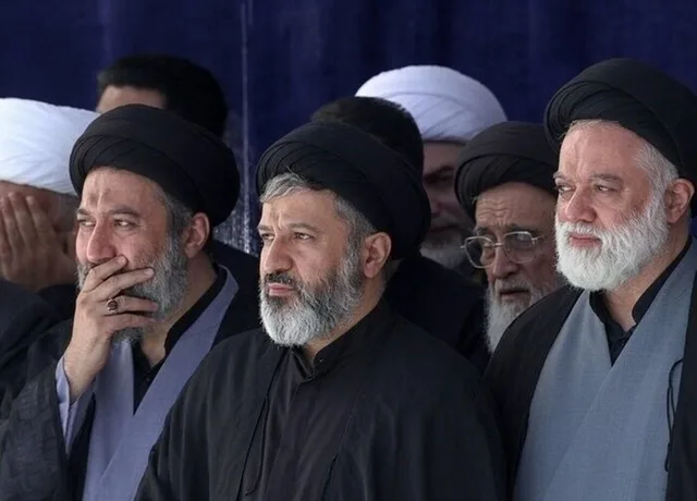 Oameni îmbrăcați în negru la funeraliile liderului iranian, exprimându-și tristețea.
