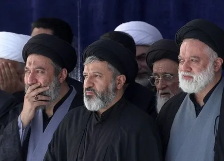 Oameni îmbrăcați în negru la funeraliile liderului iranian, exprimându-și tristețea.
