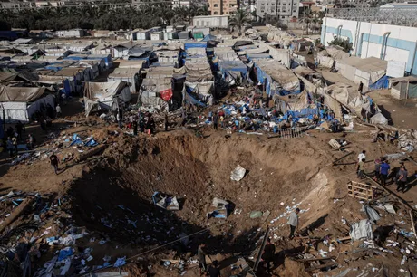 Zona distrusă din Gaza, cu corturi și dărâmături vizibile.
