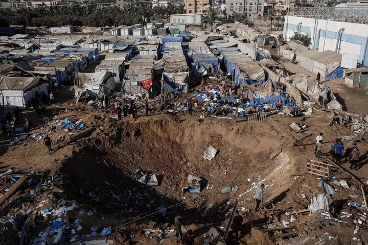 Zona distrusă din Gaza, cu corturi și dărâmături vizibile.