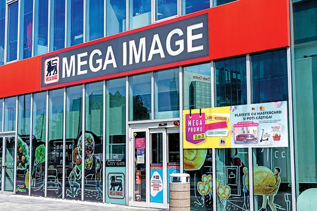 Fațada magazinului Mega Image, cu reclame și vitrine mari.