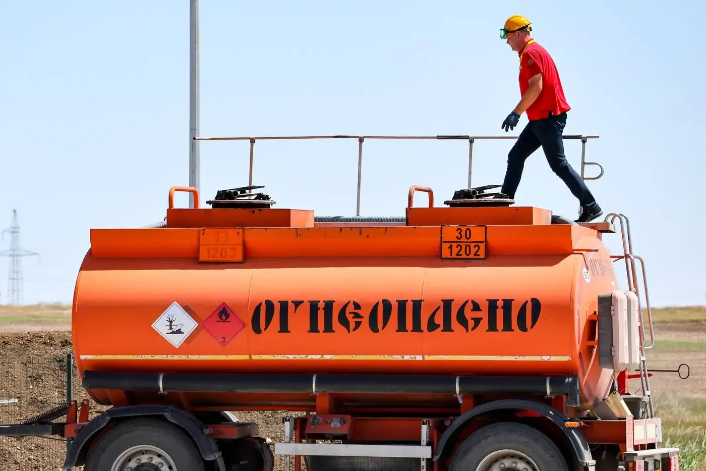 Un muncitor inspectează un rezervor de combustibil pe un camion în Crimeea.