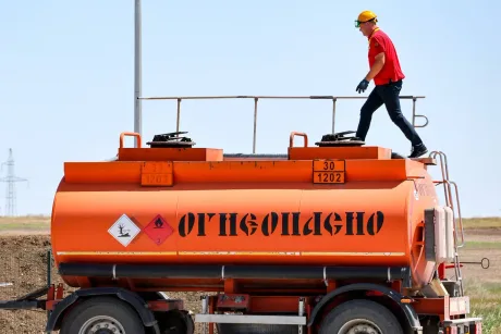 Un muncitor inspectează un rezervor de combustibil pe un camion în Crimeea.