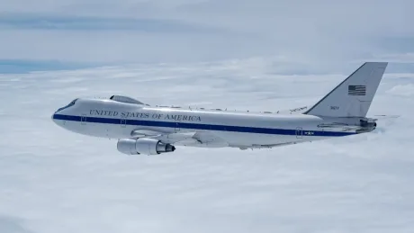 Avion militar american zburând pe un fundal albastru.