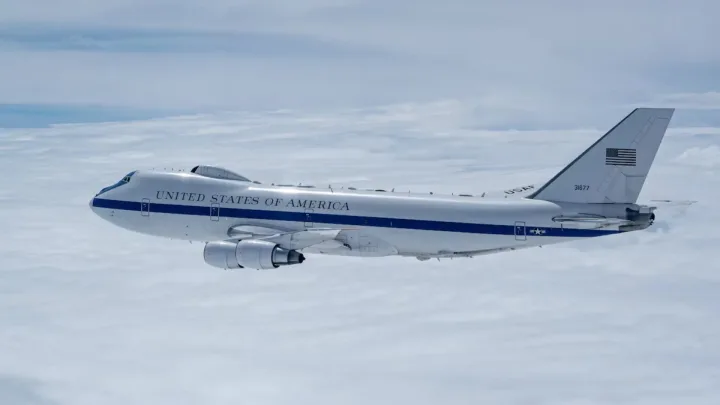 Avion militar american zburând pe un fundal albastru.