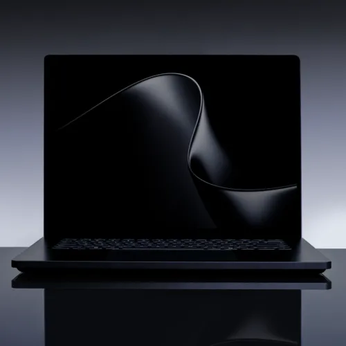 Laptop elegant cu un design minimalist, pe fundal întunecat.