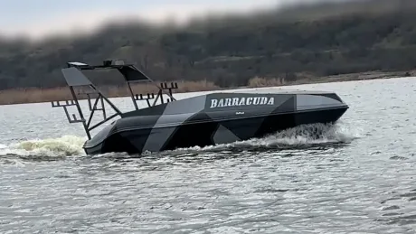 Ambarcațiune rapidă navigând pe apă, cu design modern și nume distinctiv.