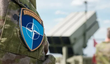 Simbolul NATO pe uniforma unui soldat, evidențiind angajamentele de apărare.