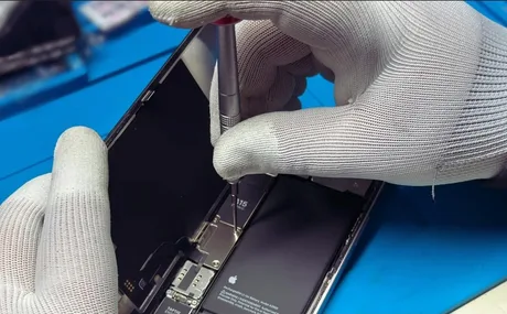 Mecanism de reparare a unui dispozitiv electronic pe un birou de lucru.