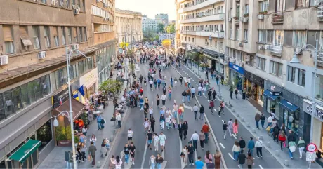 Strada plină de oameni în timpul Zilelor Bucureștiului, cu activități diverse și atmosferă festivă.