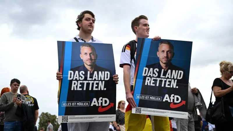 Tineri susținători ai AfD cu pliante în timpul unei campanii electorale.
