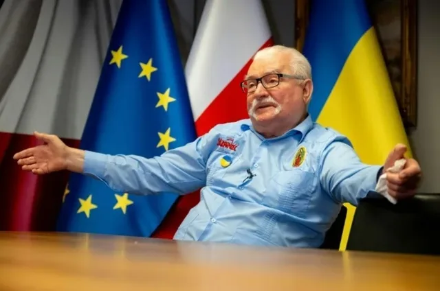 Lech Wałęsa discutând în fața steagurilor Poloniei și Uniunii Europene.