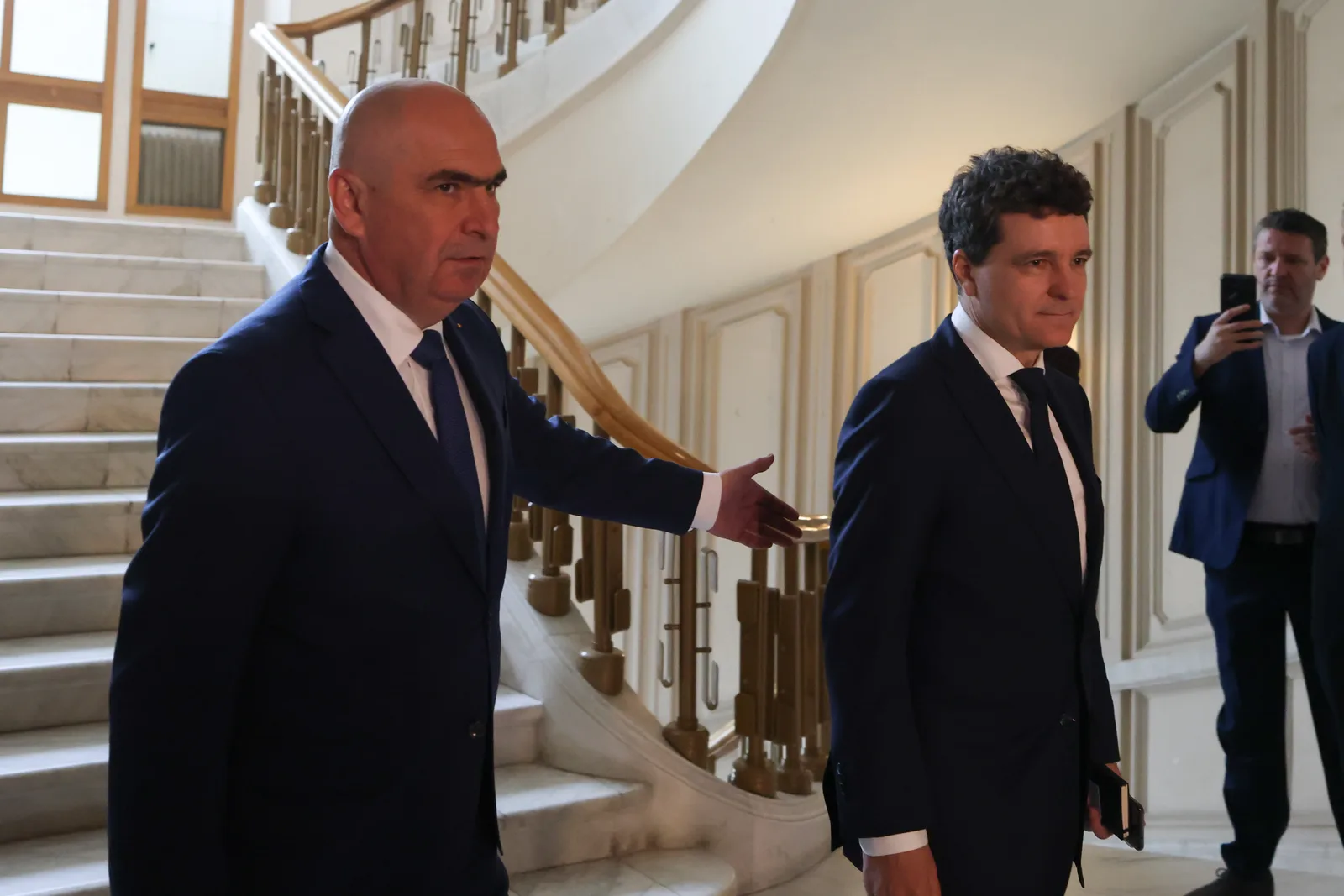 Ilie Bolojan și Nicușor Dan discutând într-un cadru oficial la Bruxelles.