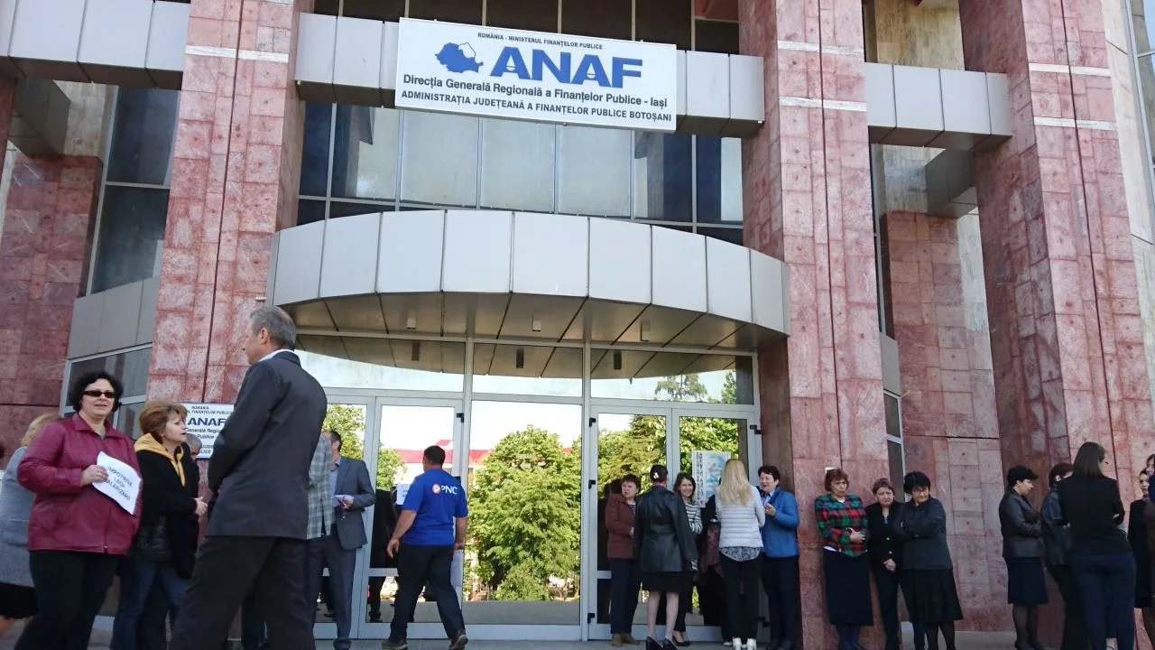 Clădirea ANAF cu oameni așteptând la intrare pentru verificări fiscale.