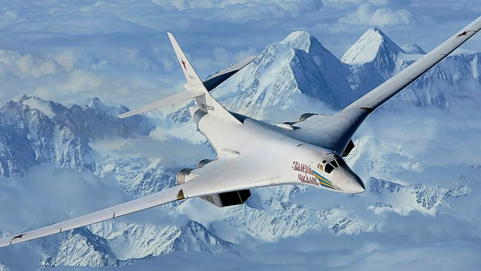 Bombardierul Tu-160 zburând deasupra munților acoperiți de zăpadă.