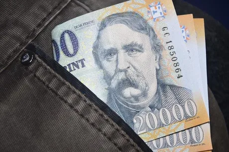Bancnote de forinți ascunse într-un buzunar, simbolizând deficitul bugetar.