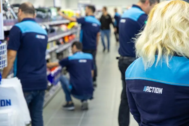 Angajați Action Retail organizând produsele într-un magazin modern.