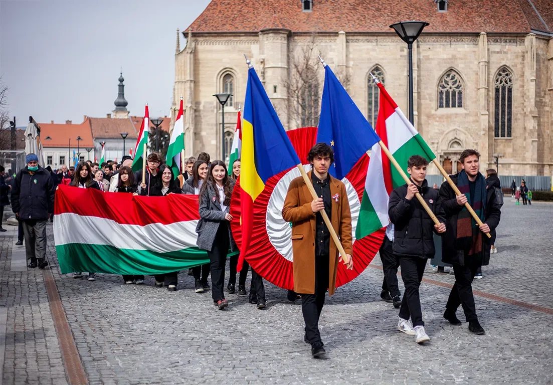 Tineri cu steaguri maghiare și românești participând la o manifestare în Budapesta.