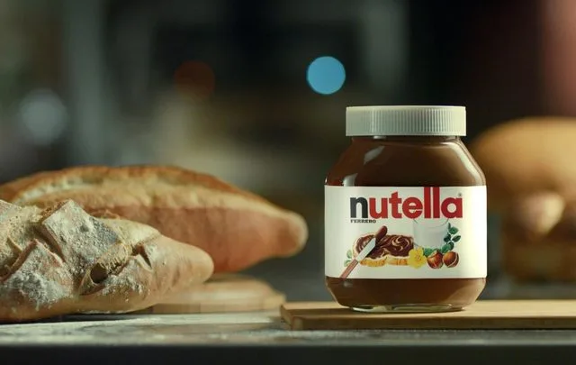 Borcan de Nutella alături de pâine proaspătă, simbol al extinderii Ferrero în România.