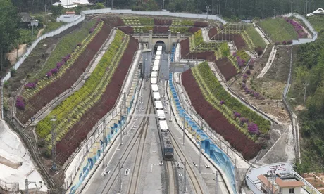 Trenuri de marfă transfrontaliere în peisaj montan, evidențiind infrastructura feroviară modernă.