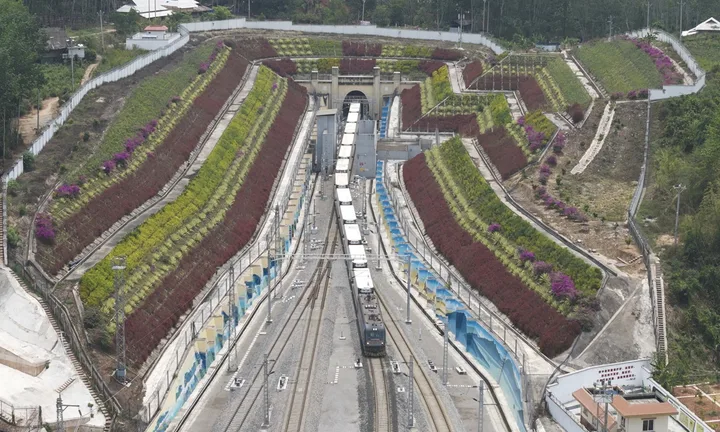 Trenuri de marfă transfrontaliere în peisaj montan, evidențiind infrastructura feroviară modernă.