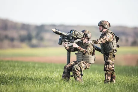 Militari pregătiți pentru misiuni externe în peisajul natural.
