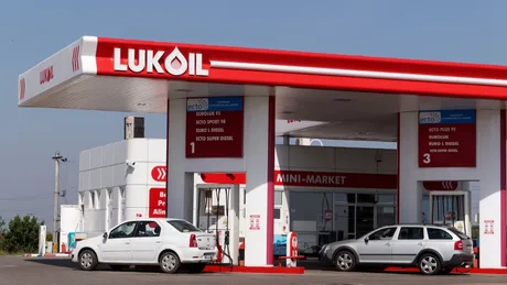 Stație de carburanți Lukoil cu mașini parcate în față.