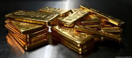 Bucăți de aur strălucitor așezate pe o suprafață metalică.