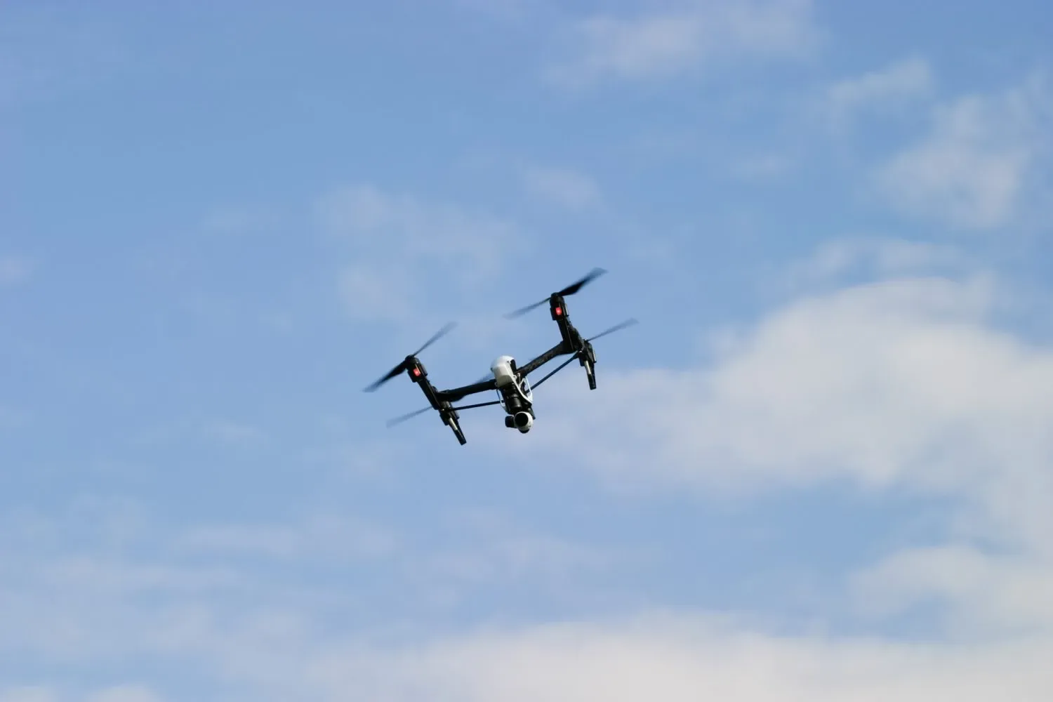 Drone în zbor pe un fundal de cer senin.