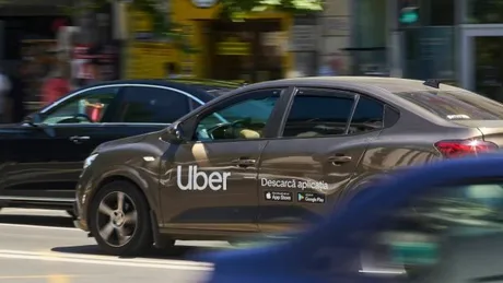 Mașini de ride-sharing circulând pe stradă, evidențiind transportul alternativ.