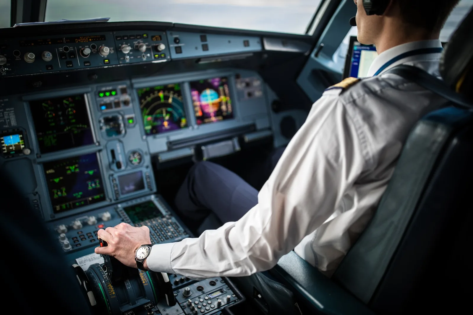 Pilot în cockpit, concentrat pe instrumentele de zbor.