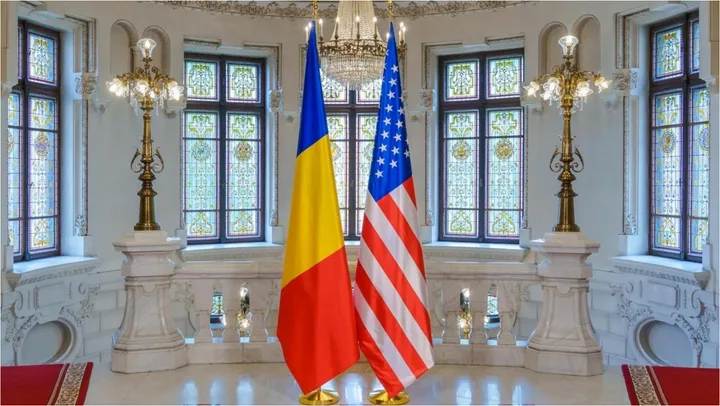 Steagurile României și SUA expuse într-un cadru elegant.
